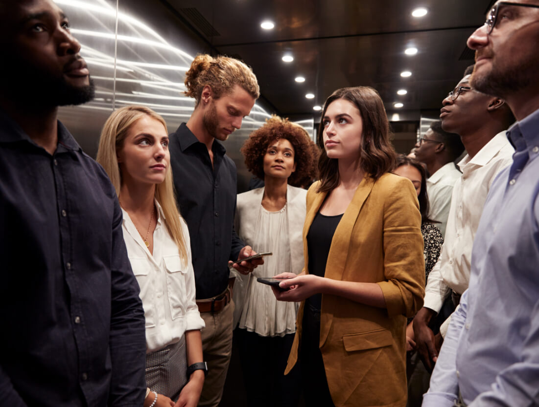 A lady in thought on a crowded elevator.